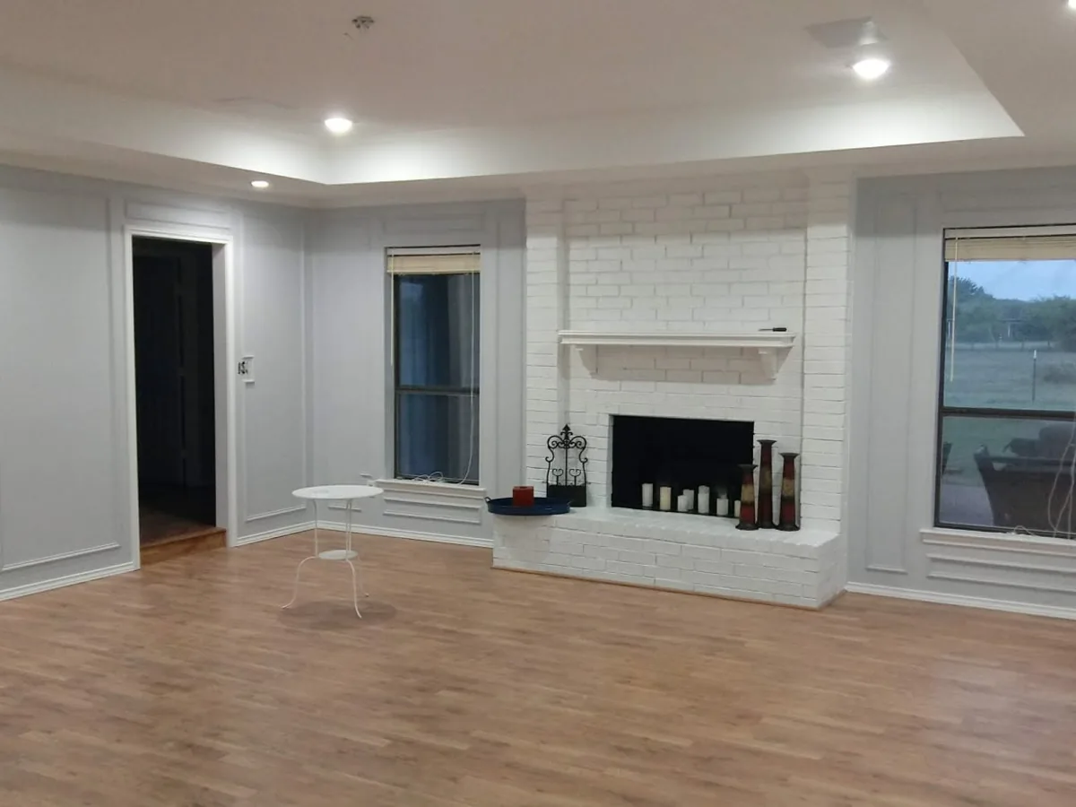 Living room painted white with a whitewashed brick fireplace