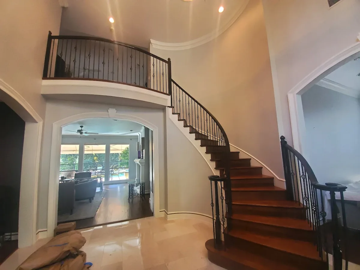 Two story entry and curved staircase painted in warm white