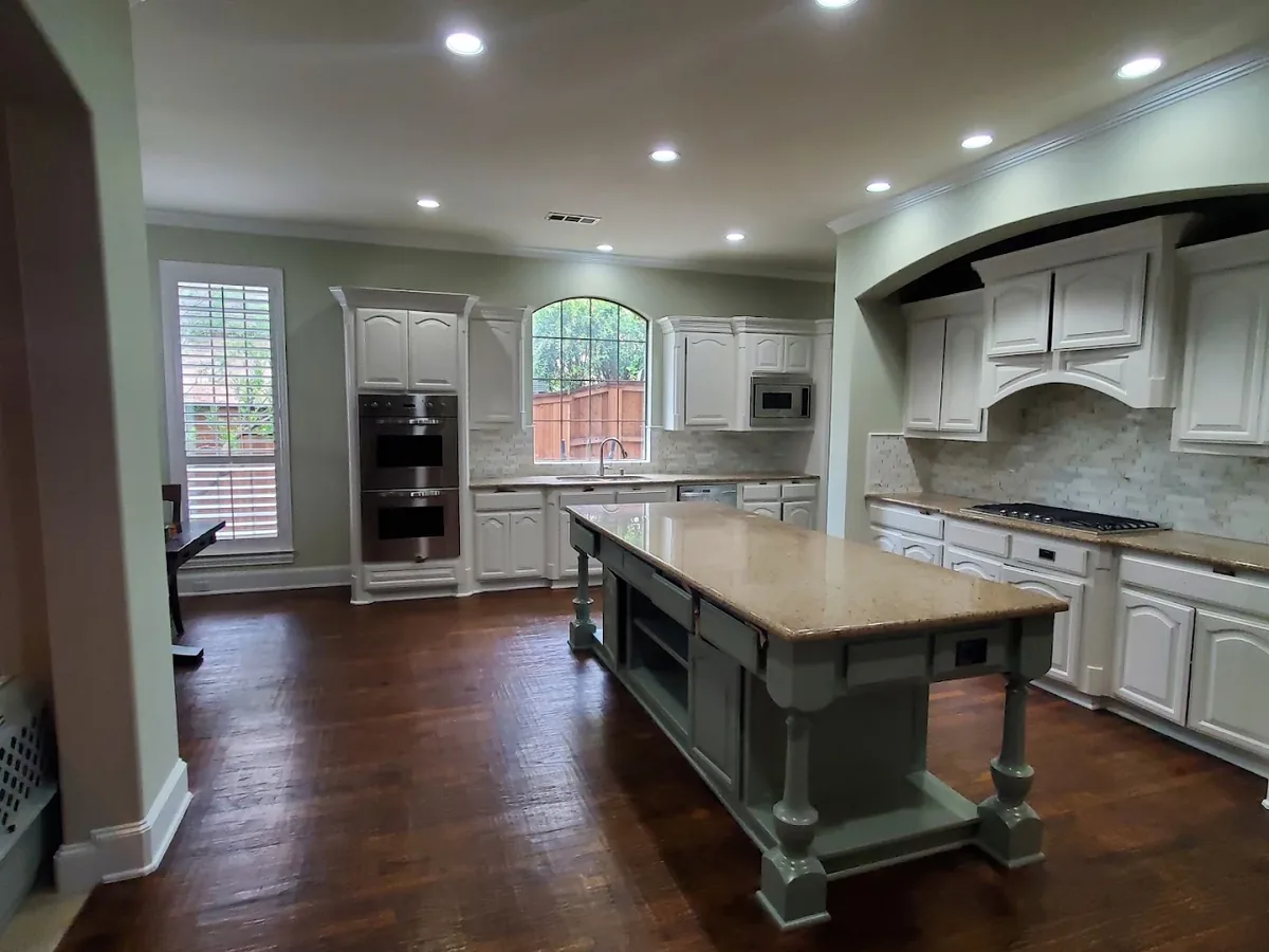 White painted kitchen cabinets with a green island